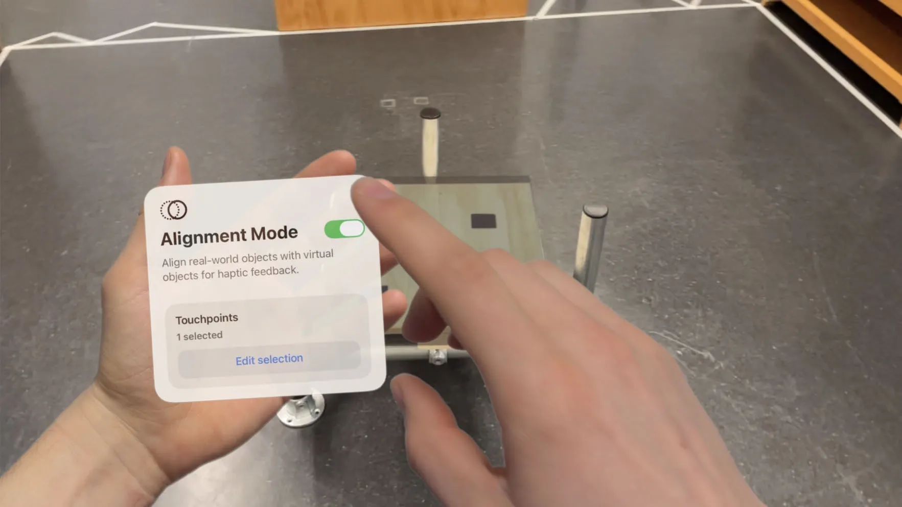 A finger switching off Alignment Mode on the palm menu, with a physical seat frame standing in the room behind it